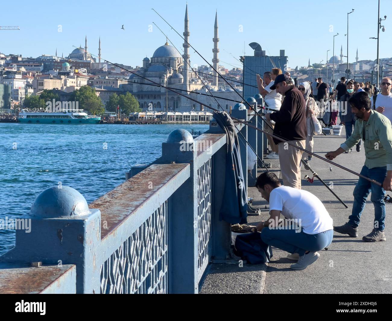 Istanbul, Türkei - 5. Mai 2024: Altehrwürdige Angelschnüre ziehen über den Bosporus von der Galata-Brücke. Stockfoto