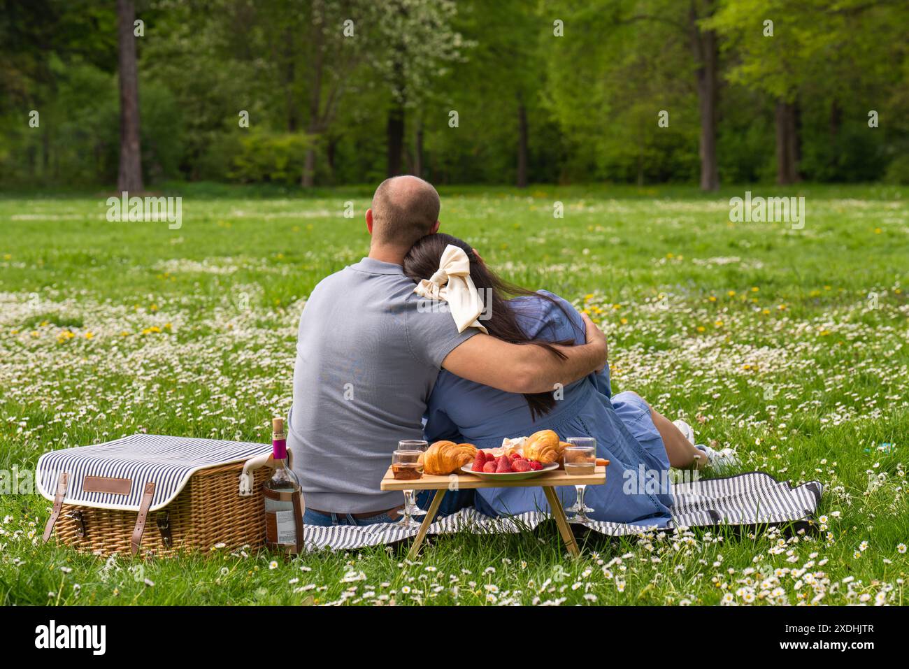 Glückliches schwangeres Paar, das Zeit zusammen auf einem Picknick im Freien verbringt. Rückansicht die Familie erwartet ein Kind. Schwangerschaft. Liebe füreinander Stockfoto