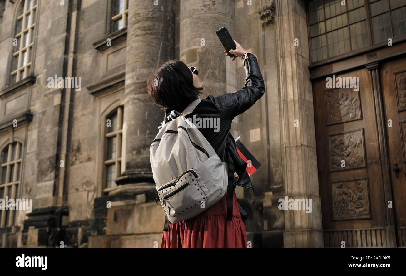 Attraktive Wanderungen für weibliche Touristen mit Deutschlands Flagge im historischen Zentrum von Dresden, Fotos von Sehenswürdigkeiten Stockfoto