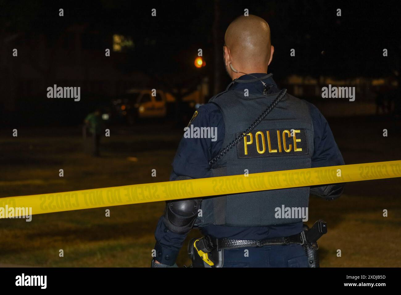 Santa Barbara, Kalifornien, USA. Juni 2024. Ein Polizist steht Wache, sein gelber Polizeiaufkleber passt zum gelben Tatortband, während er auf das fast leere Feld blickt, wo es nur Stunden zuvor Hunderte von Zelten dort gab. In den frühen Morgenstunden des 23. Juni 2024 sperrten mehr als 4o Strafverfolgungsbeamte die Eingänge zum UCSB-Campus und ließen das gesamte Pro-Palästina-Lager von Marburger Müllsammlern abbauen und wegschleppen. (Kreditbild: © Amy Katz/ZUMA Press Wire) NUR REDAKTIONELLE VERWENDUNG! Nicht für kommerzielle ZWECKE! Stockfoto