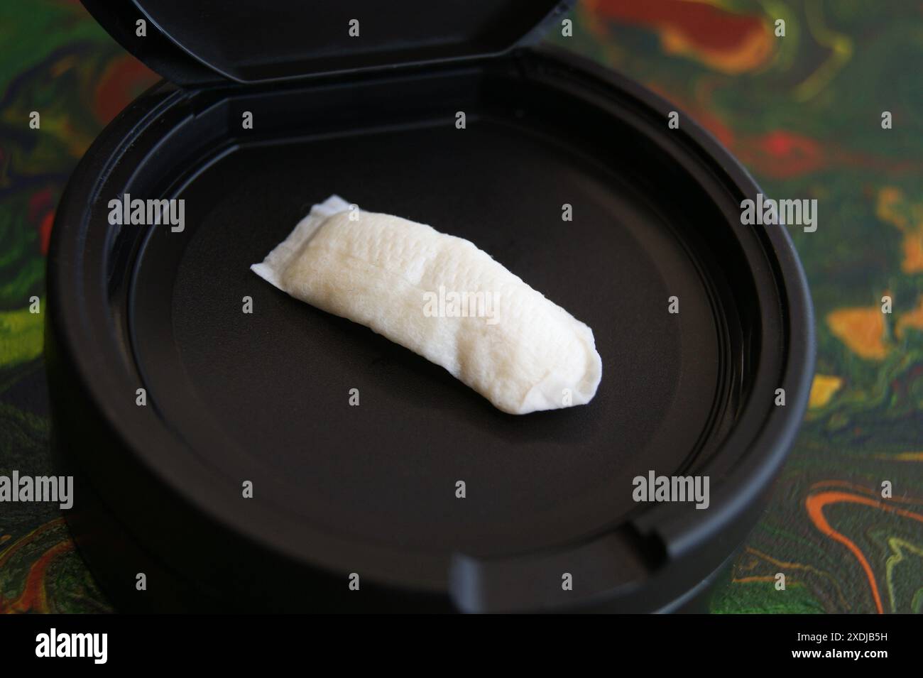 Benutzter Nikotinbeutel auf schwarzer Verpackung Stockfoto