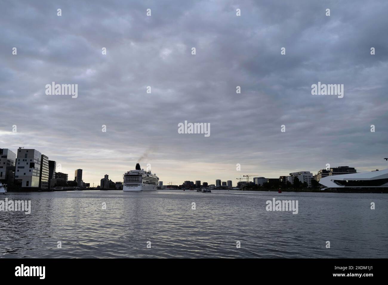 Ein Kreuzfahrtschiff verlässt den Hafen von Amsterdam am Abend. Amsterdam, Niederlande Stockfoto