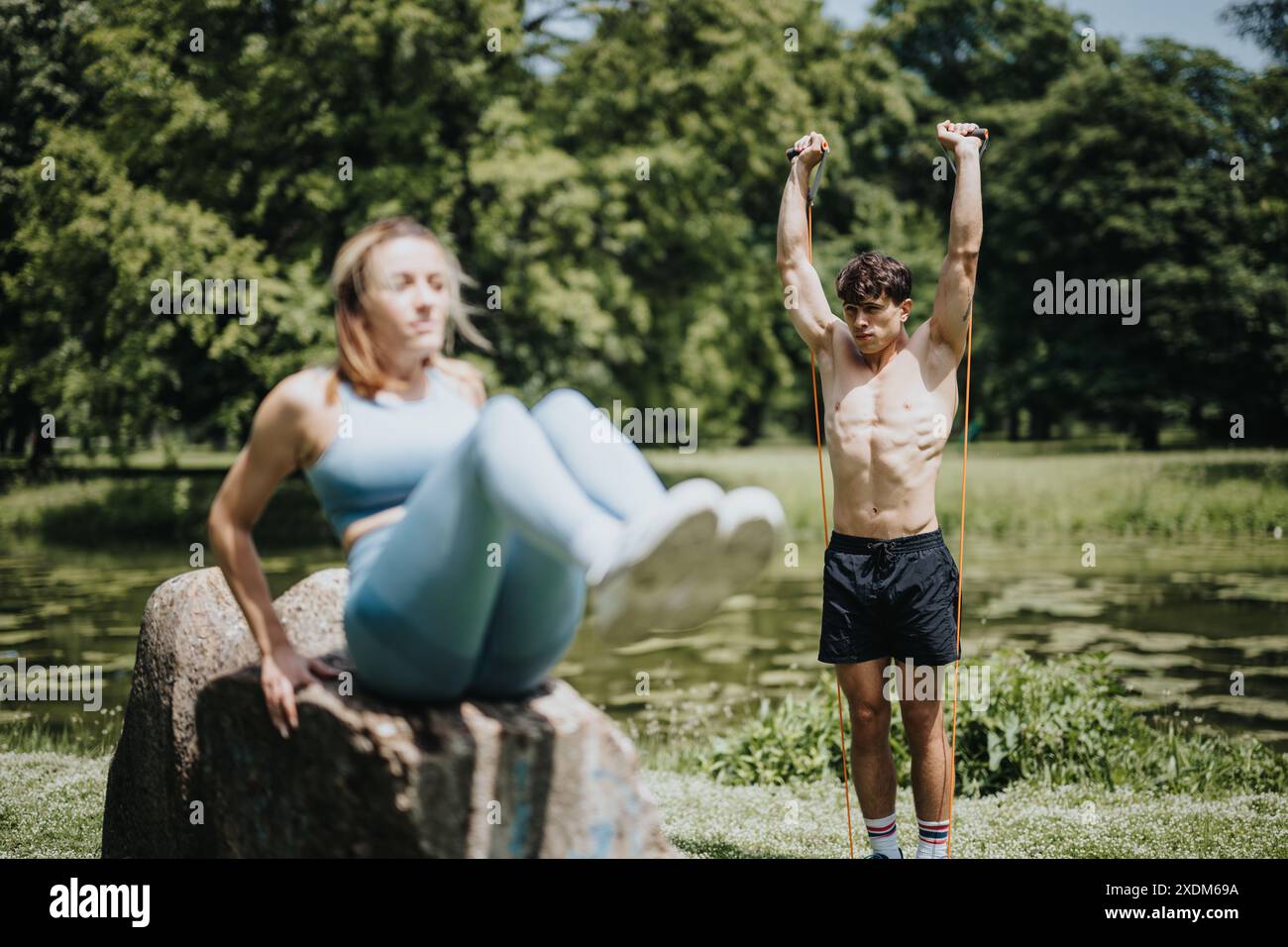 Junger Mann und Frau, die gemeinsam im Park Calisthenics-Übungen durchführen Stockfoto