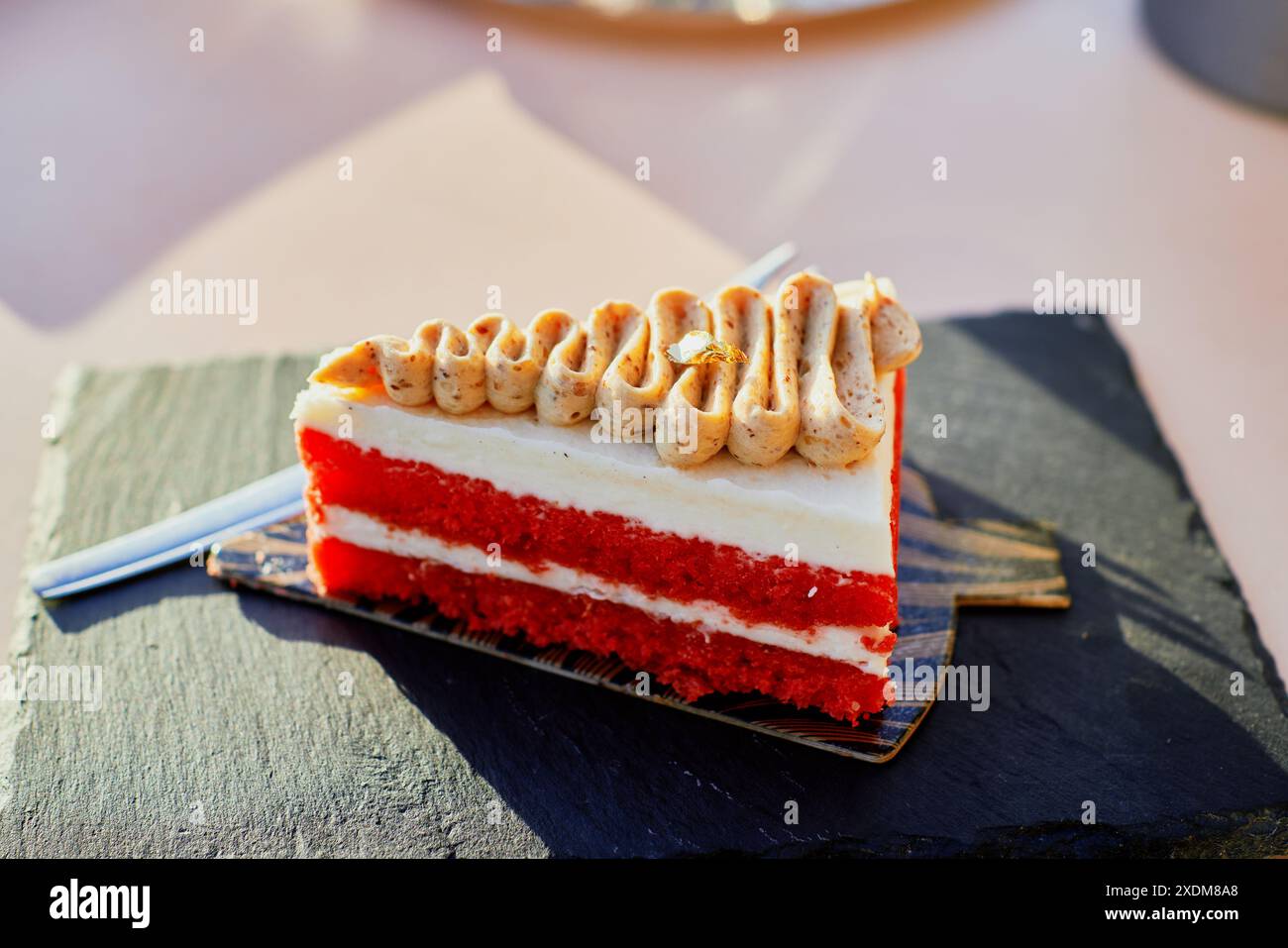 Ein Stück Kuchen auf einem schwarzen Teller Stockfoto