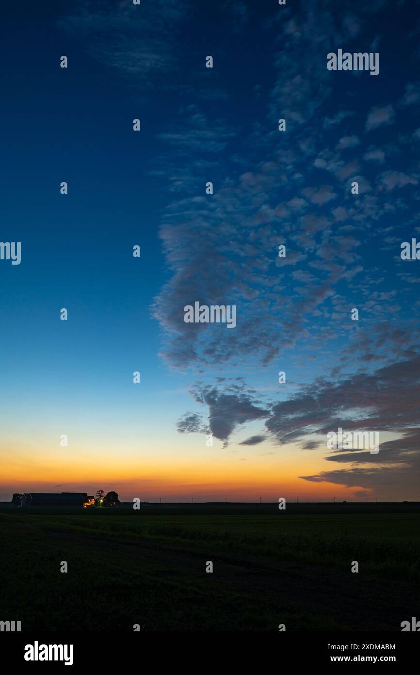 Die Wolken der Altcumulus-Schafe werden während der Mittsommernacht im Juni durch die Dämmerung wunderschön beleuchtet Stockfoto