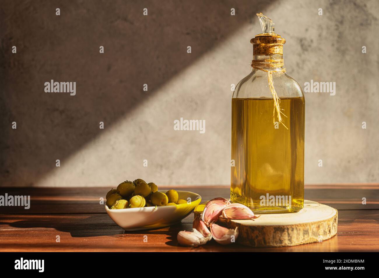 Olivenölflasche mit Oliven und Knoblauch Stockfoto