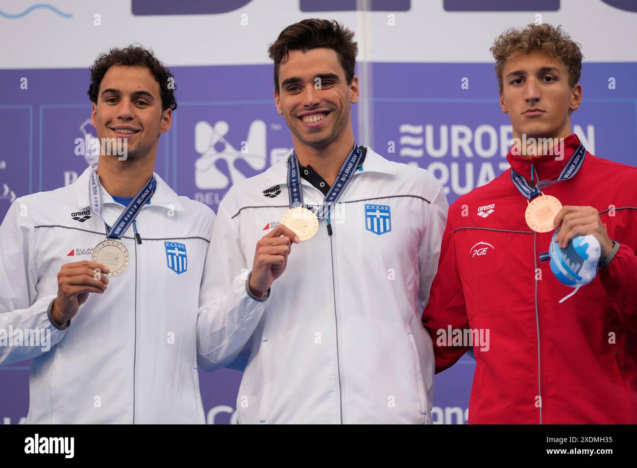 Greece's Apostolos Christou, centre, celebrates his gold medal in Men's 100m Backstroke with silver medalist Evangelos Makrygiannis, left, also from Greece, and bronze Ksawery Masiuk from Poland at the European Aquatics Championships in Belgrade, Serbia, Sunday, June 23, 2024. (AP Photo/Darko Bandic) Stockfoto