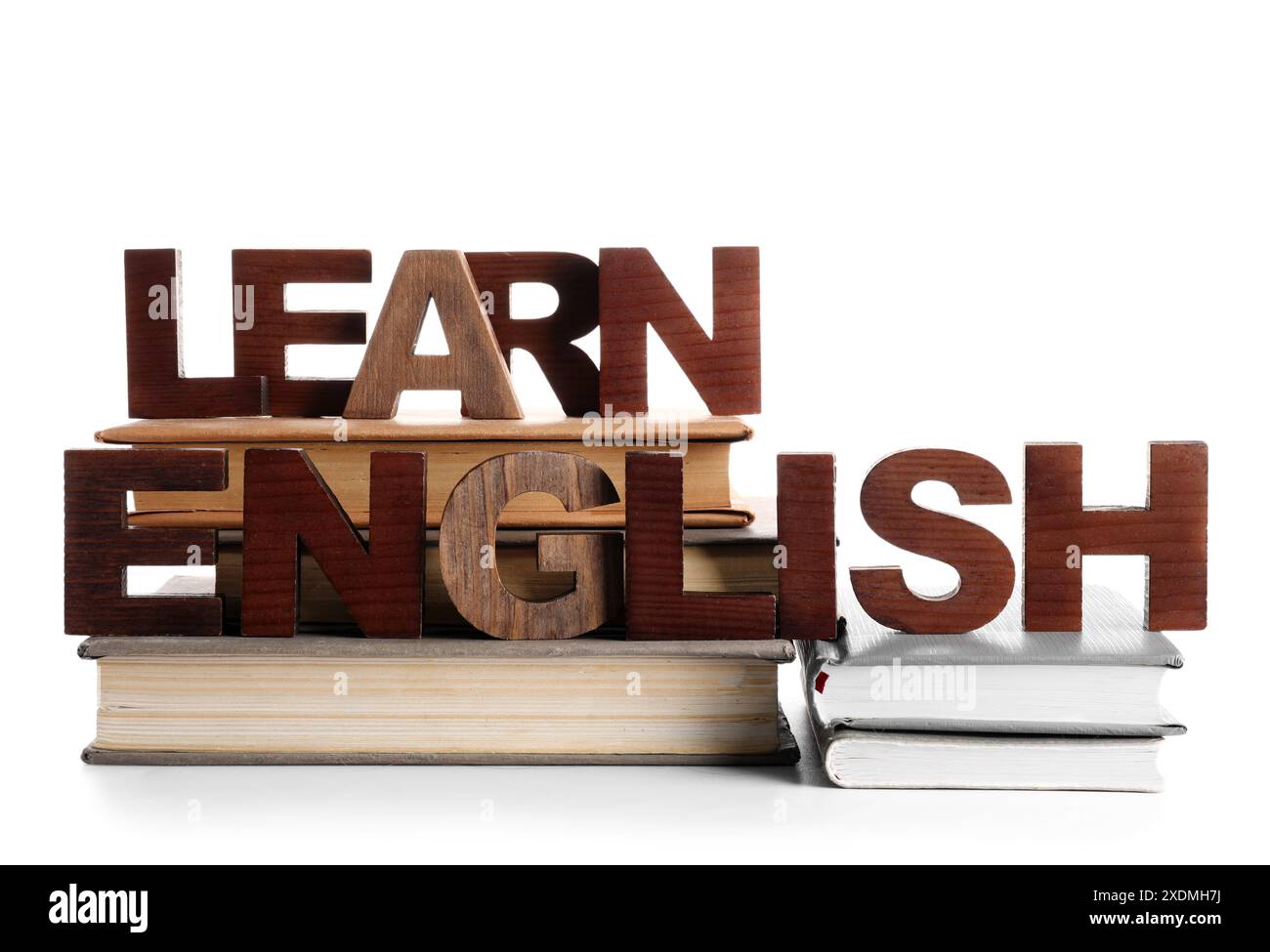 Text LERNEN SIE ENGLISCH aus hölzernen Buchstaben mit Büchern isoliert auf weißem Hintergrund Stockfoto