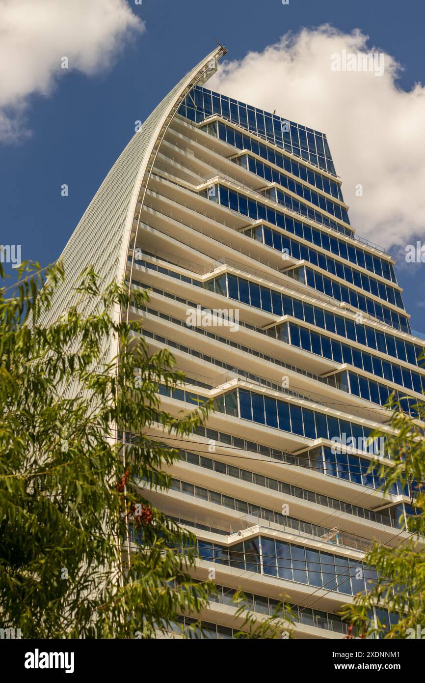 Ein modernes Hochhaus in Austin, Texas, mit einer einzigartigen segelähnlichen Kurve. Das schlanke Design verfügt über zahlreiche Balkone mit Glasgeländern. Stockfoto