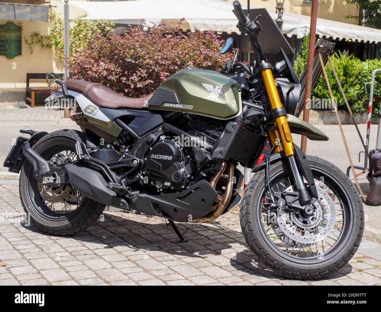 Castellarquato, Italien - 22. Juni 2024 Silberflagge-Rallye , kraftvolles modernes, grünes Motorrad auf Kopfsteinpflaster in sonniger urbaner Umgebung Stockfoto