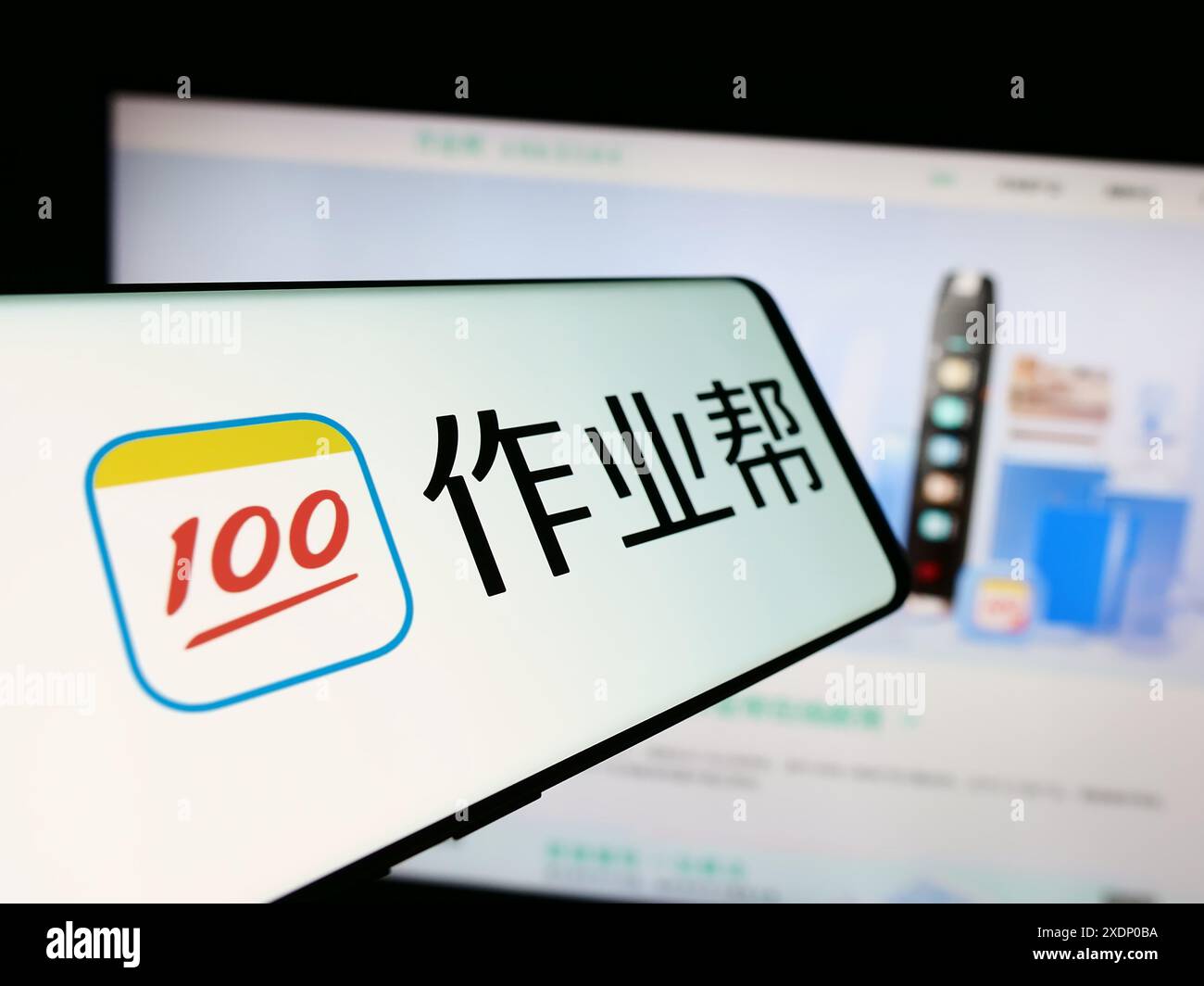 Mobiltelefon mit Logo der chinesischen Online-Bildungsplattform Zuoyebang vor der Website. Fokussieren Sie sich auf die linke Mitte des Telefondisplays. Stockfoto
