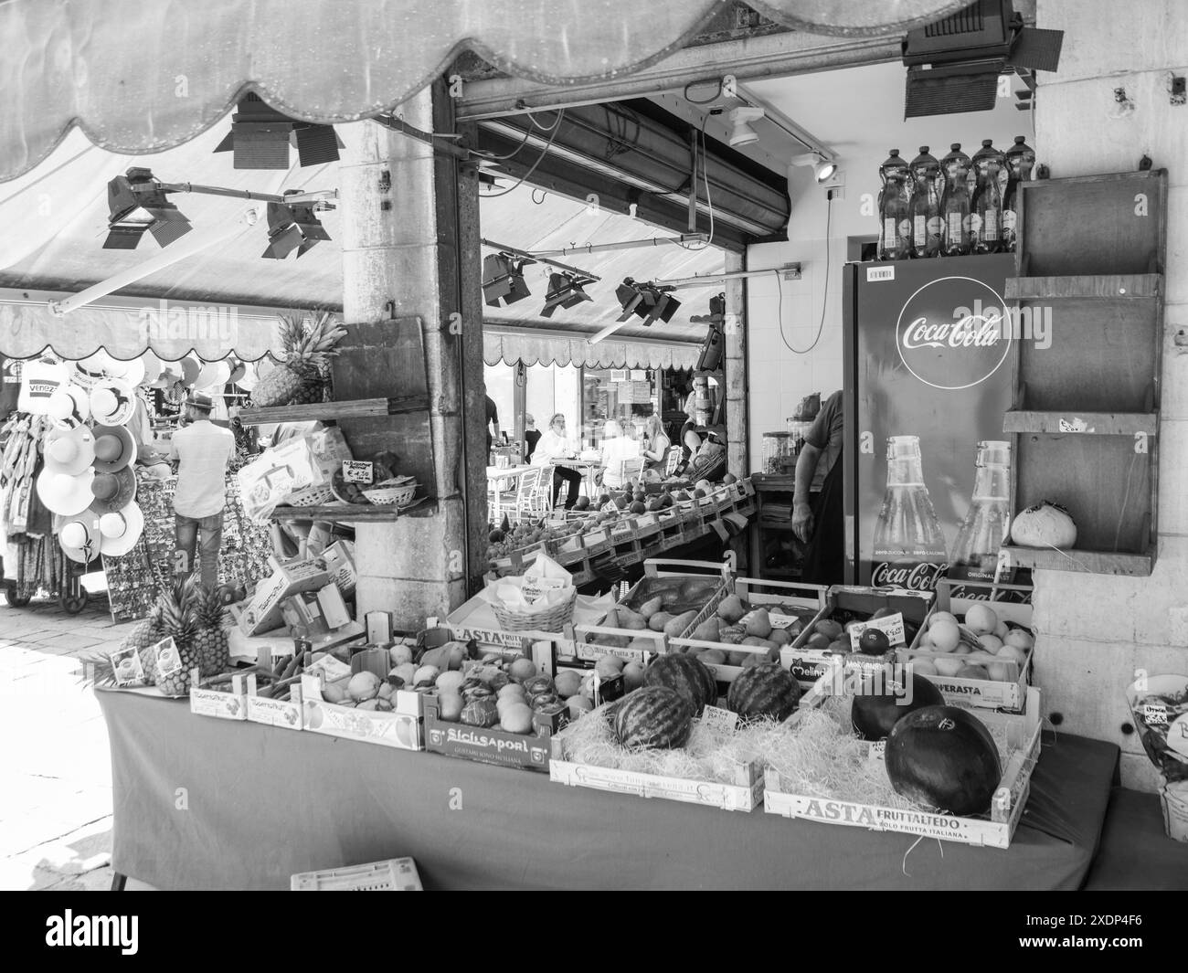 Venedig, Italien - 30. Juni 20220 Schwarzweißbild eines Obstverkäufers, der seine Produkte an einem Marktstand arrangiert Stockfoto