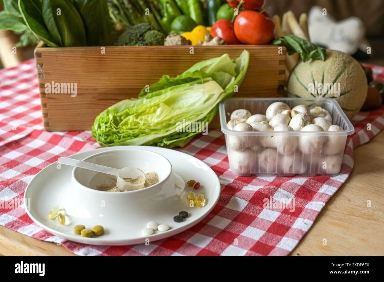Nahrungsergänzungsmittel in Form von Tabletten oder Pulver im Gegensatz zu frischem Gemüse voll von Vitaminen, Mineralien und Ballaststoffen, gesunde Ernährung Konzept, s Stockfoto
