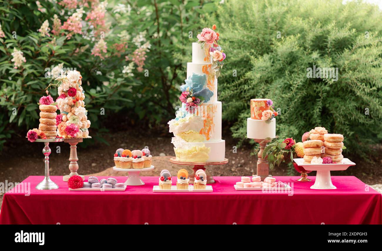 Eleganter Hochzeits-Desserttisch mit einem gestuften Kuchen und verschiedenen Süßigkeiten Stockfoto