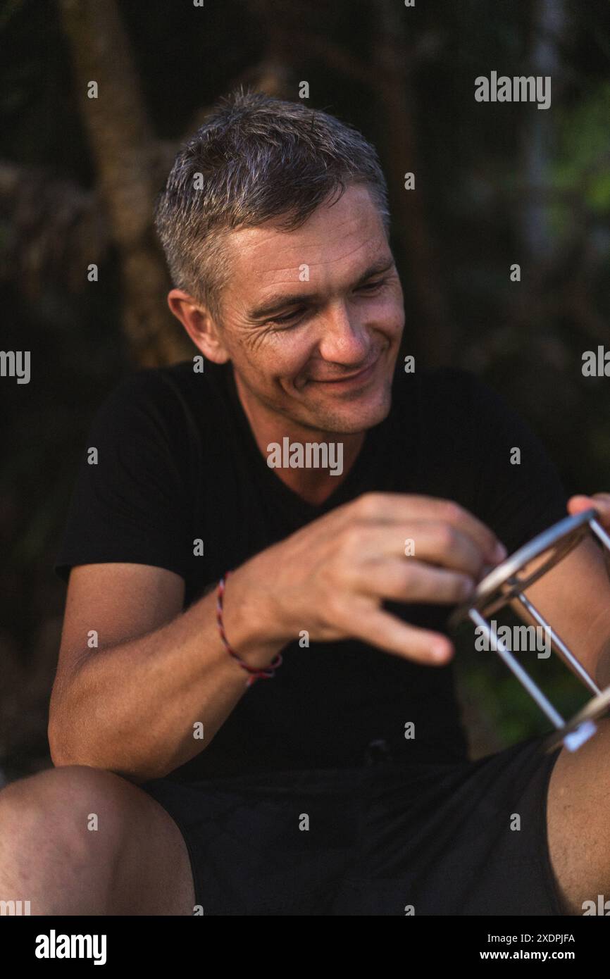 Ein Mann mittleren Alters am Strand von Bali, lächelt. Stockfoto