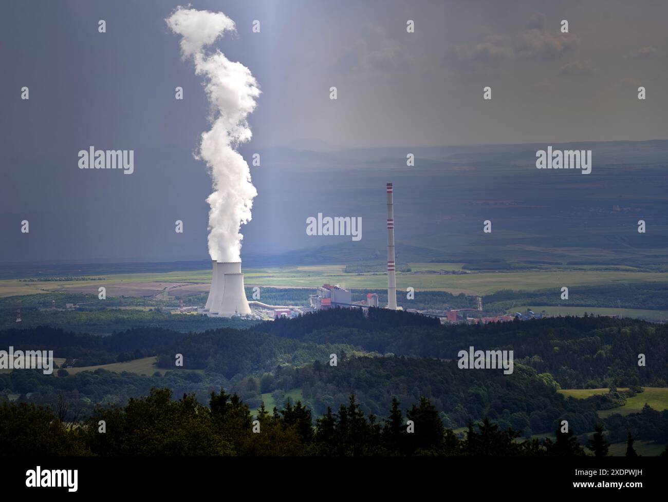 Weißer Dampf, der aus dem Kühlturm eines Kohlekraftwerks in der Tschechischen Republik an einem nebligen Regentag aufsteigt Stockfoto