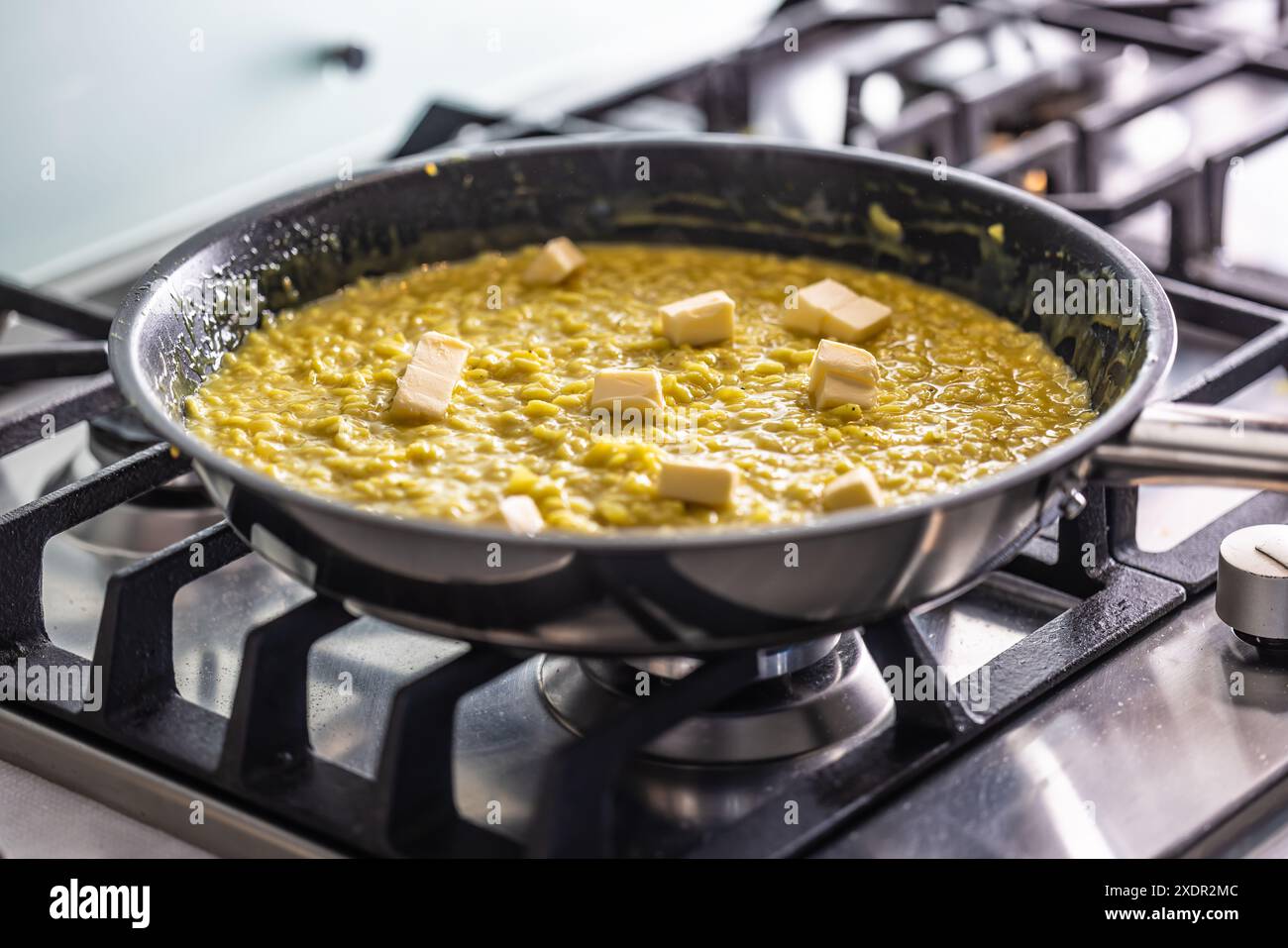 Ein Teil der Herstellung von Risotto ist das Hinzufügen von Butter am Ende Stockfoto