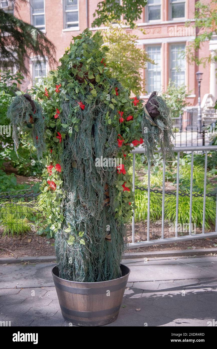 NYC BUSHMAN, Ein Performance-Künstler, der wie ein Rosenbusch gekleidet ist und Passanten Angst einjagt. Im Washington Square Park in New York. Stockfoto