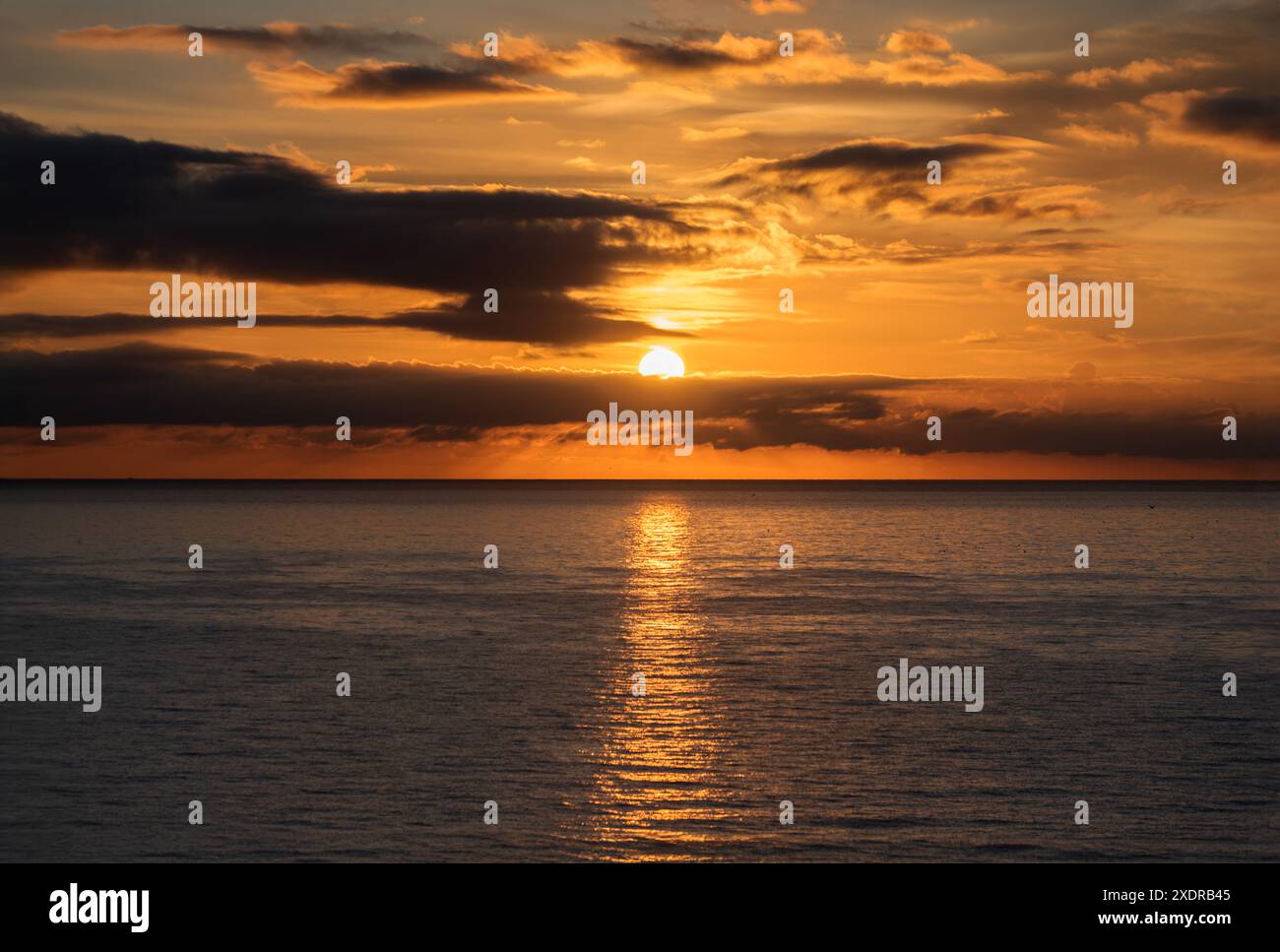 Sonnenuntergang über dem Wasser mit Vögeln, die gegen das Sonnenlicht auf dem Mittelmeer fliegen Stockfoto
