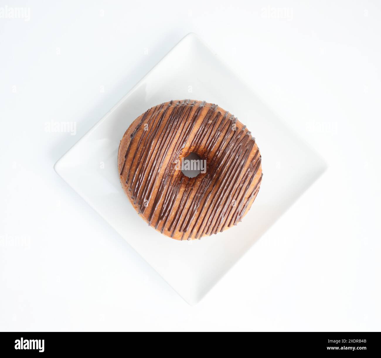 Schokoladen-Donuts isoliert, braune Donuts mit weißen Streifen, Kakao-Donuts auf weißem Hintergrund Stockfoto