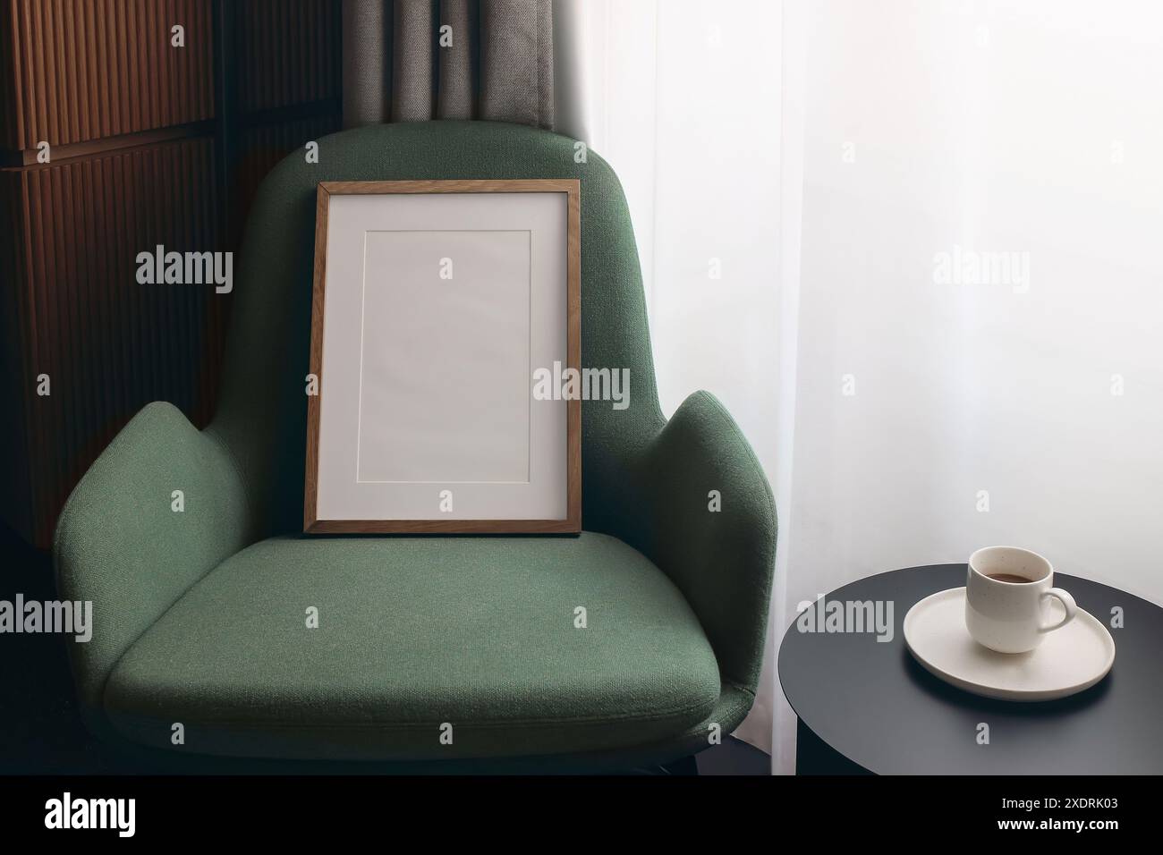 Moderne Retro-Komposition skandinavischer Wohnzimmereinrichtung mit grünem Designsessel. Leerer hölzerner Bilderrahmen, Poster-Vorlage. Kaffee t Stockfoto