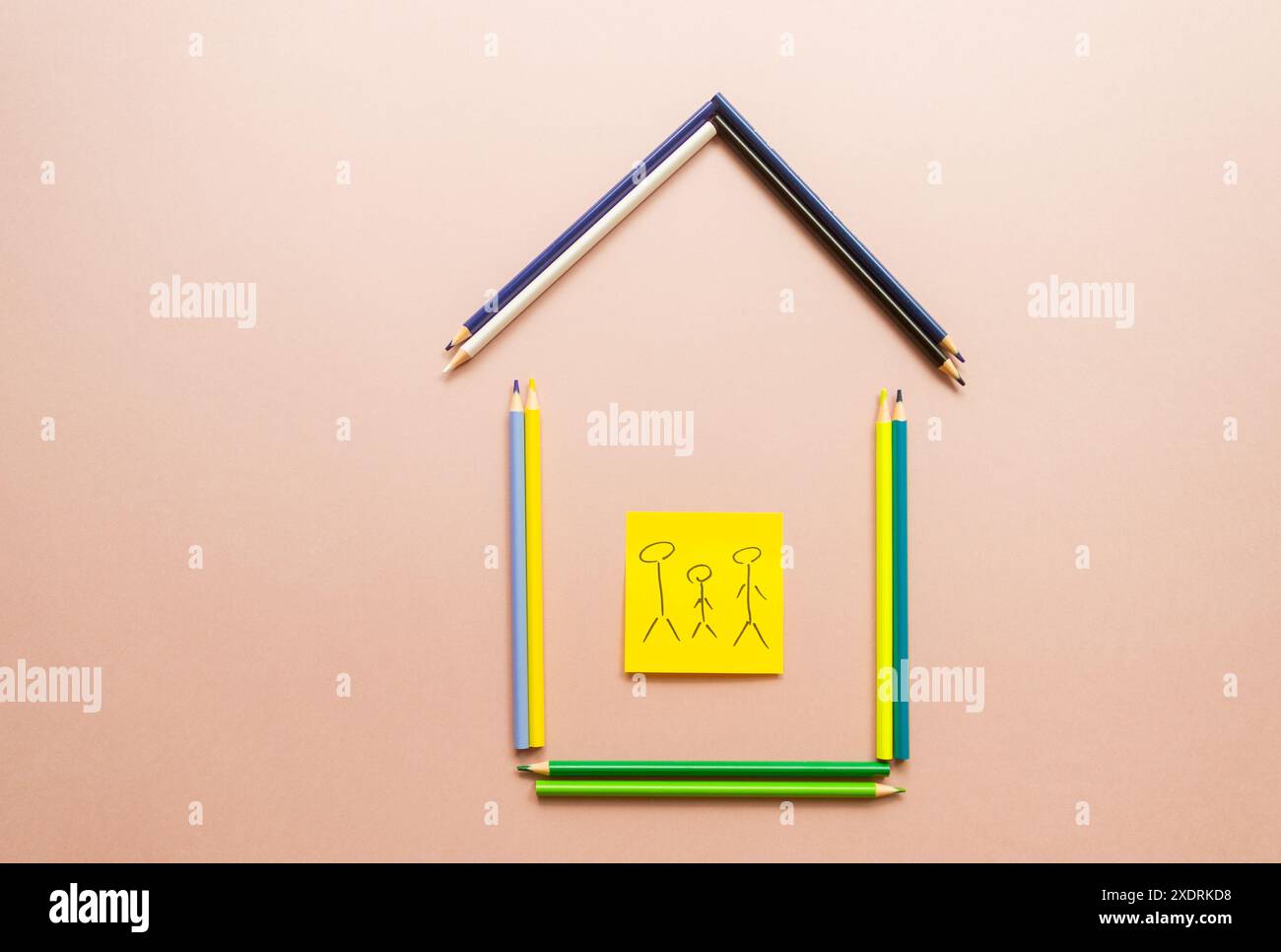 Konzept von Familie und Wohnkomfort, Bild eines Hauses aus Buntstiften und einer Familie im Haus, Immobilienkonzept, Schulkonzept Stockfoto