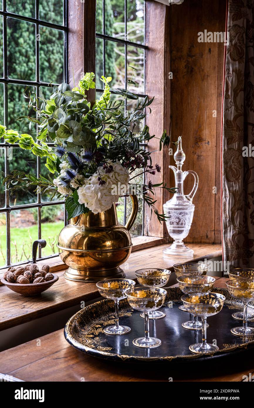Messing-Ewer mit verzierten Sektgläsern auf vergoldetem Regency-Tablett in Tudor Farmhouse aus dem 16. Jahrhundert, Hertfordshire, England, Großbritannien. Stockfoto