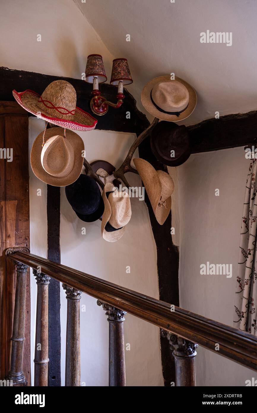Sammlung von Hüten in der Holztreppe des Bauernhauses Tudor aus dem 16. Jahrhundert, Hertfordshire, England, Großbritannien Stockfoto