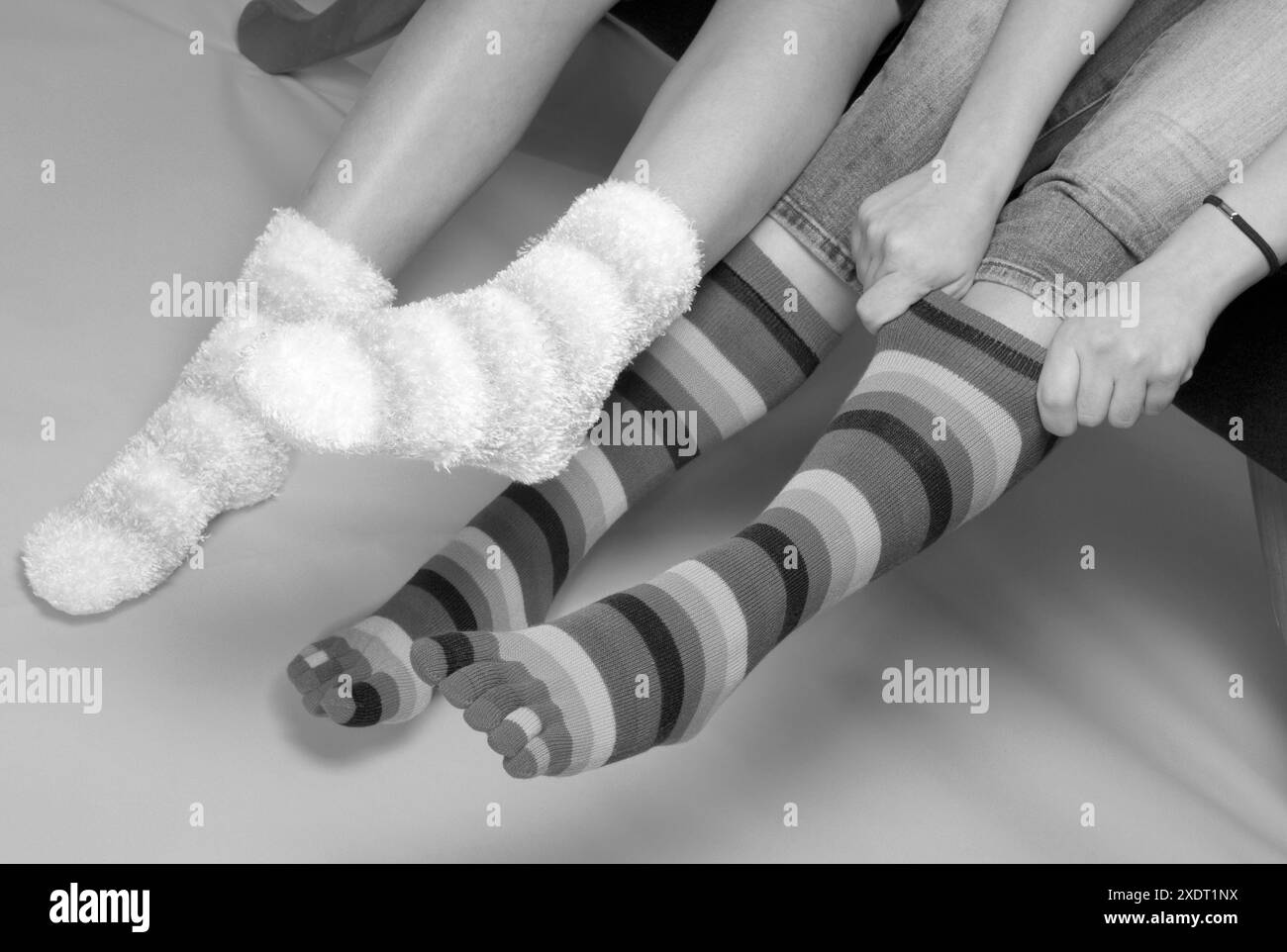 Beine und Füße von zwei Teenager-Mädchen in bunten Socken. USA Stockfoto