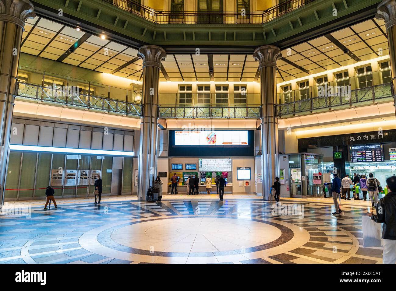 Inneres des Marunouchi-Südtors des Bahnhofs Tokio bei Nacht. Nur wenige Leute bekommen Tickets und gehen durch Schranken. Stockfoto