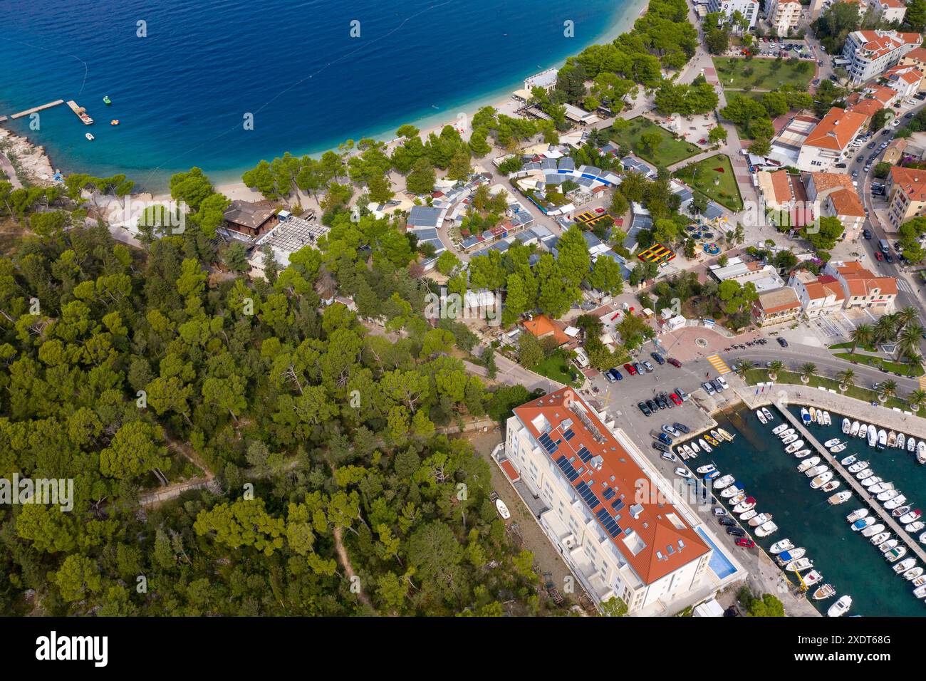 Blick aus der Vogelperspektive auf die gekrümmte Küste und die Stadt Makarska. Kroatien. Schiffe im Hafen, grüne Wälder, Stockfoto