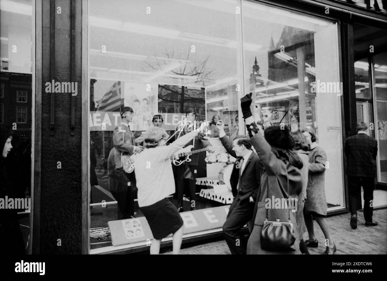 Beatlemania - Beatles Fans - 1960er Jahre Mode - die Beatles im Fenster der Modekette Kreymborg am Grote Markt in Haarlem, 1964 Stockfoto