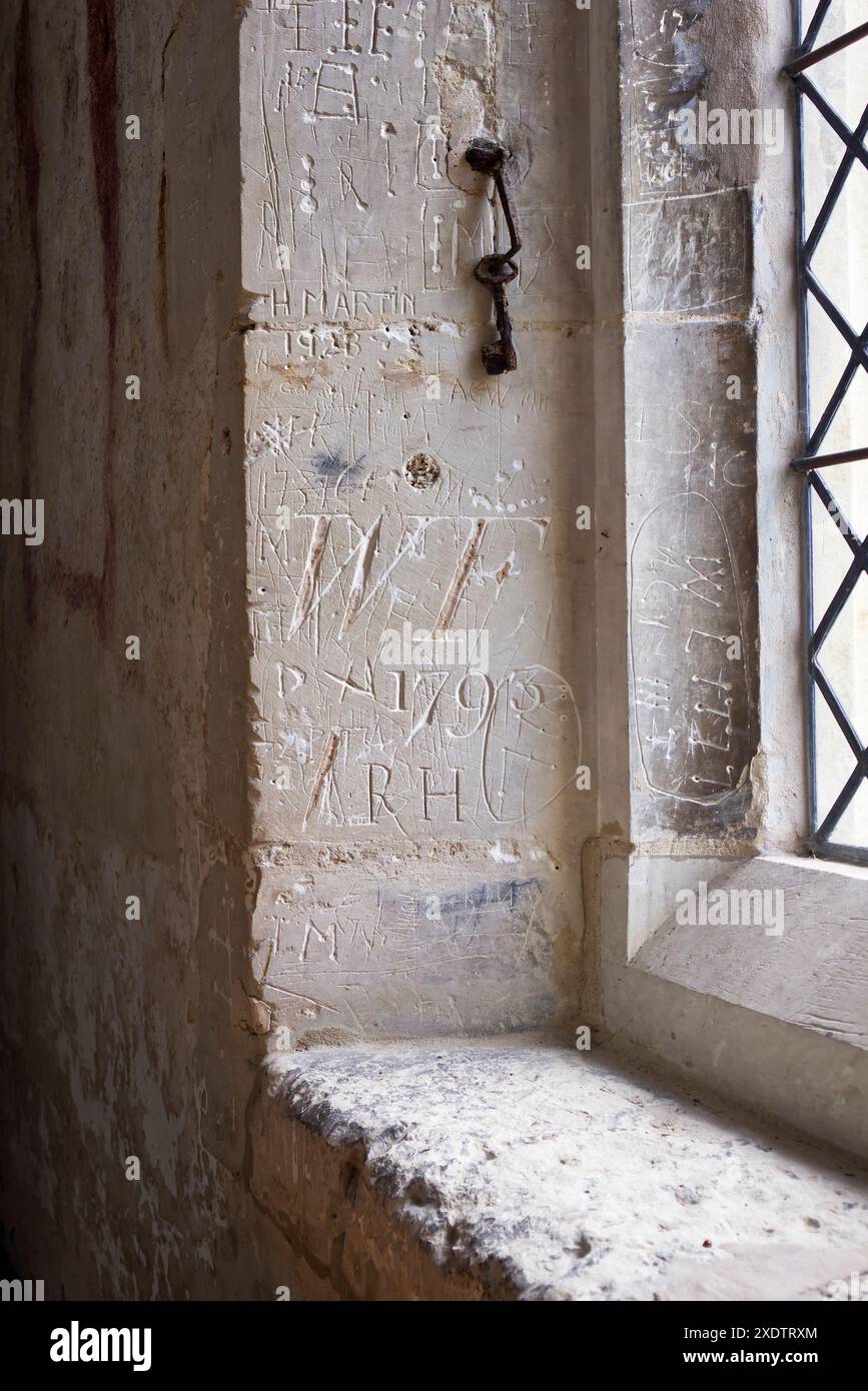 Historischer Vandalismus neben einem Fenster in All Saints und St Andrew's Church in Kingston, Cambridgeshire Stockfoto