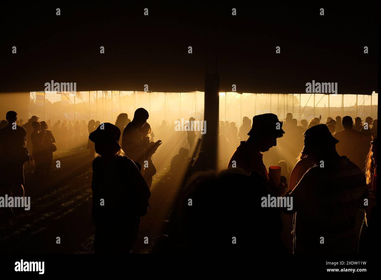 Silhouette Menschen mit Sonnenuntergang, die Musik auf einem Festival in England genießen Stockfoto