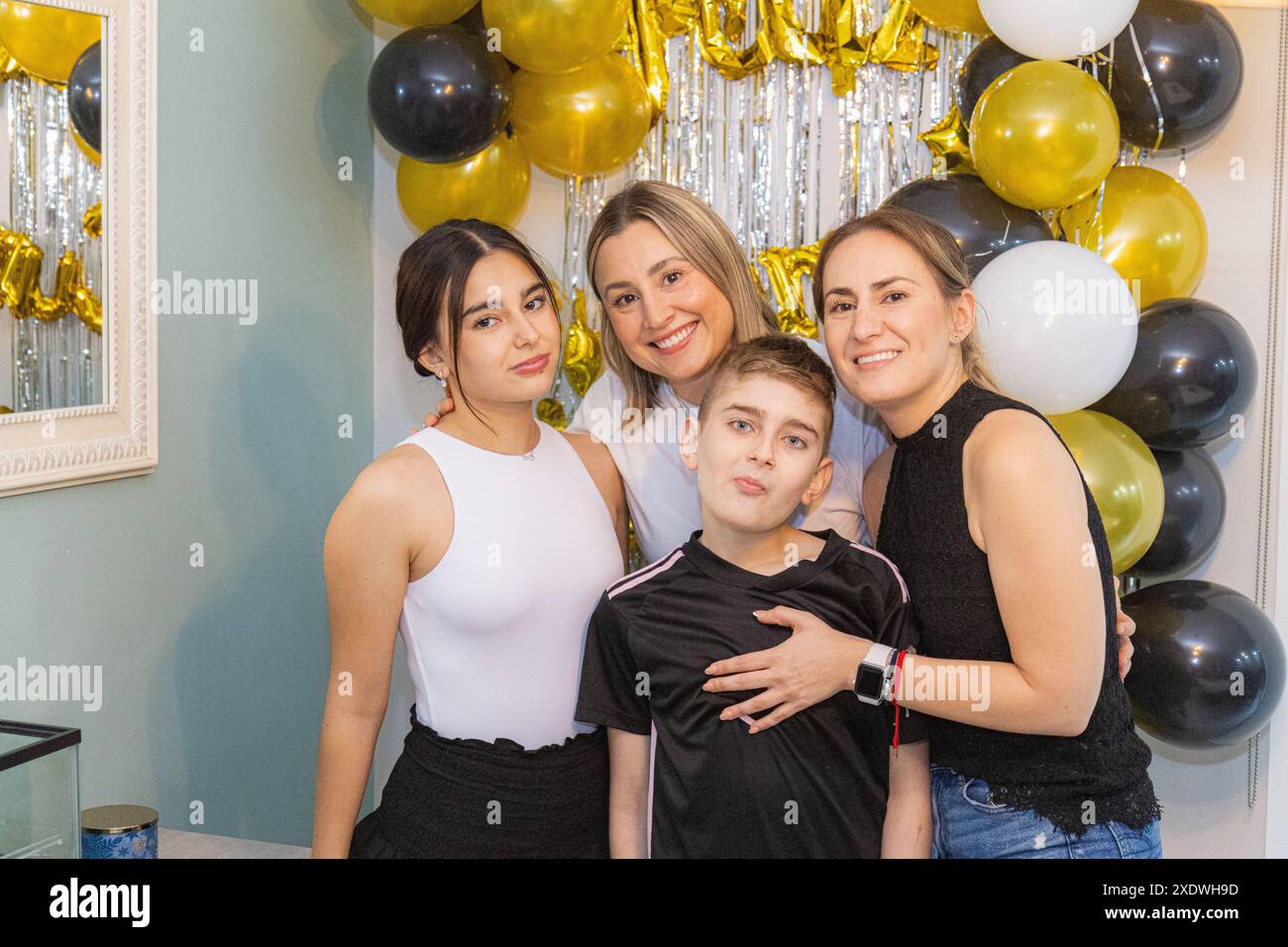 Geburtstagskind mit Familie, die lustige Gesichter macht Stockfoto