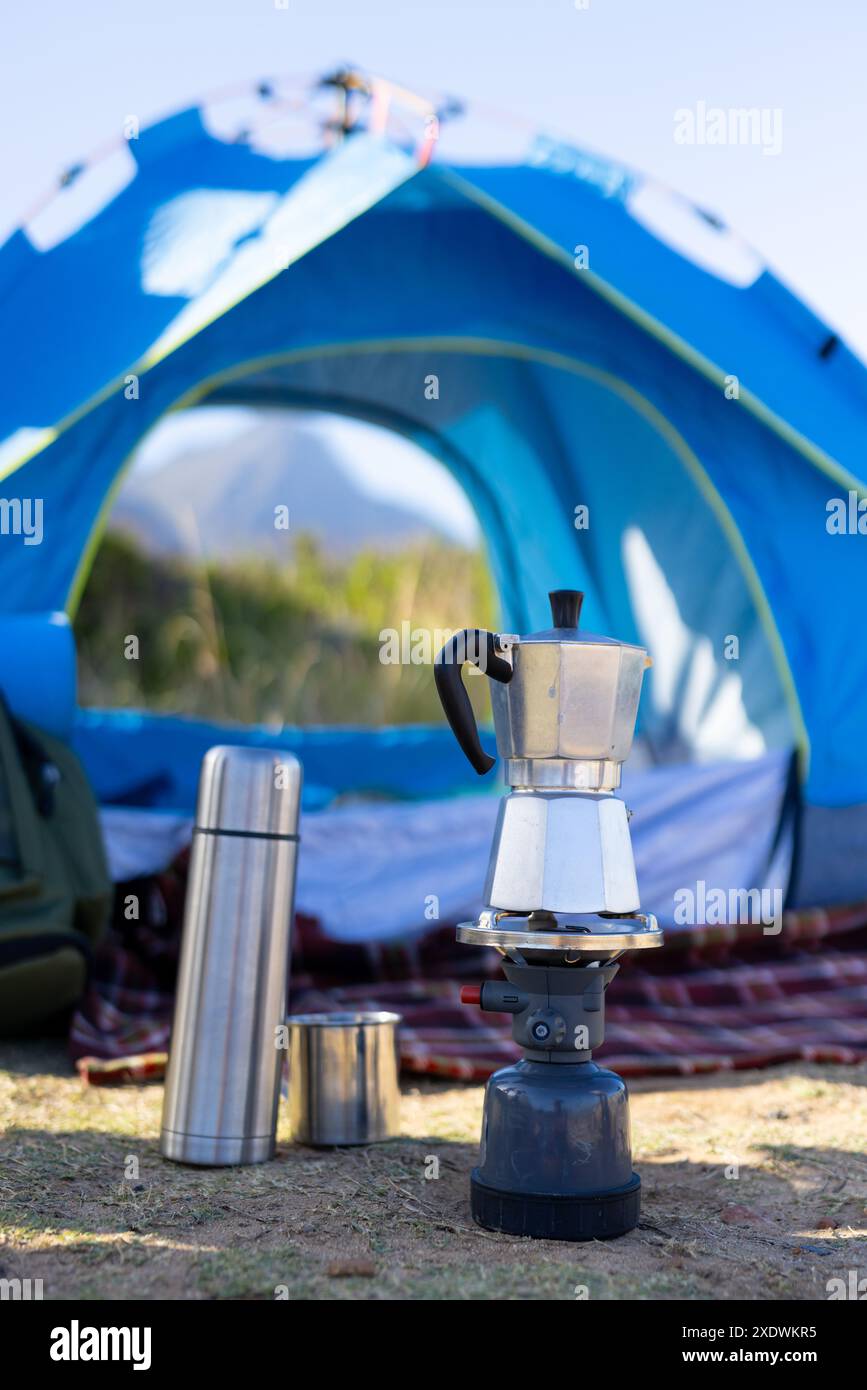 Camping mit blauem Zelt, tragbarem Herd und Kaffeemaschine bei Bergwanderungen, Kopierraum Stockfoto