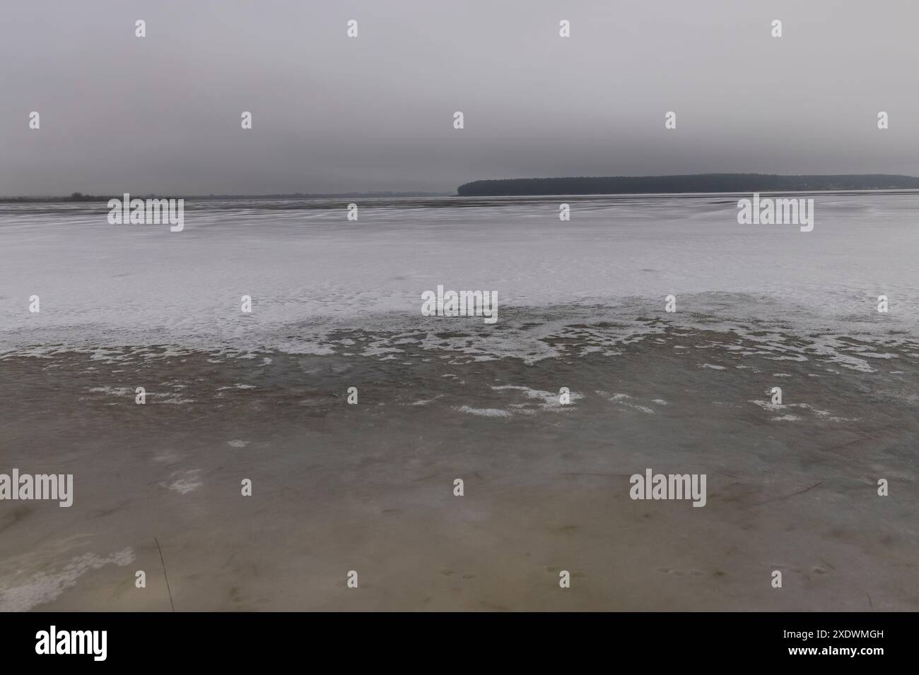 Gefrorener See im Winter bei bewölktem Wetter, Eis auf dem See bei Frost Stockfoto