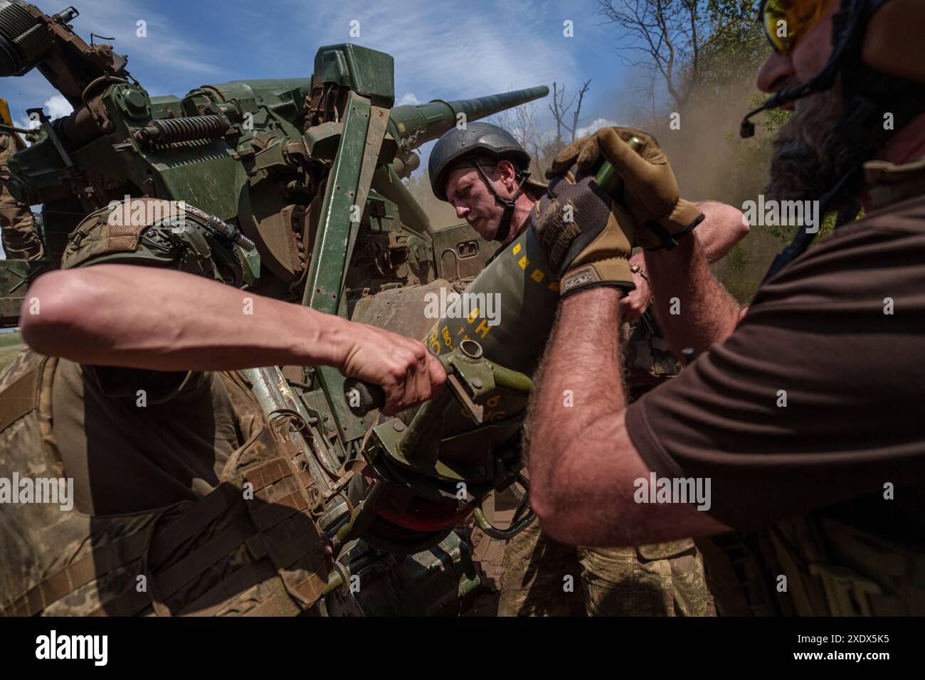 Ukrainian soldiers of 43rd artillery brigade load 203mm shell into 2s7 self-propelled howitzer before firing towards Russian positions at the frontline in Donetsk region, Ukraine, Monday, June 24, 2024. (AP Photo/Evgeniy Maloletka) Stockfoto