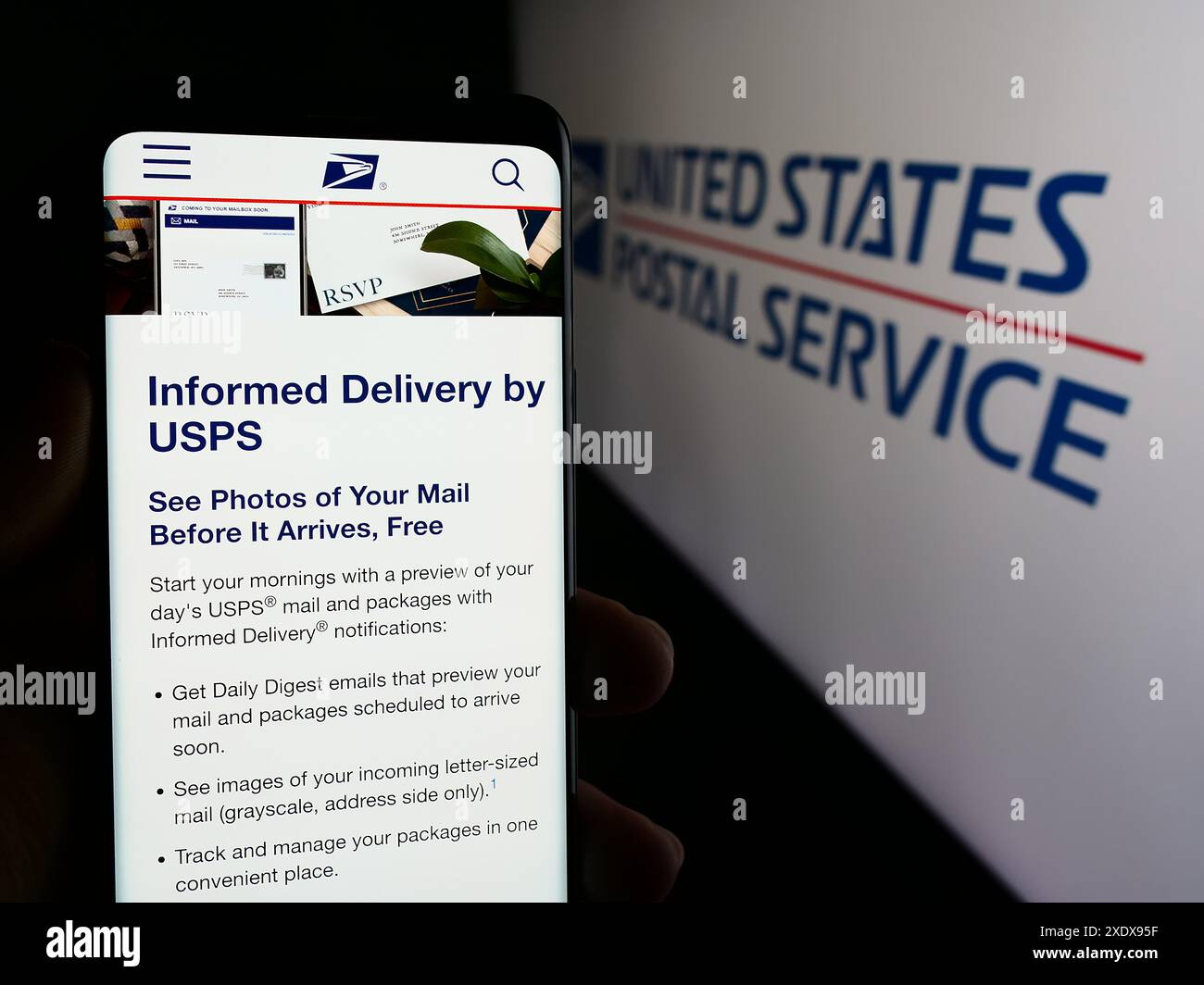 Person, die ein Mobiltelefon hält, mit Webseite der US-amerikanischen Agentur United States Postal Service (USPS) vor dem Logo. Konzentrieren Sie sich auf die Mitte des Telefondisplays. Stockfoto