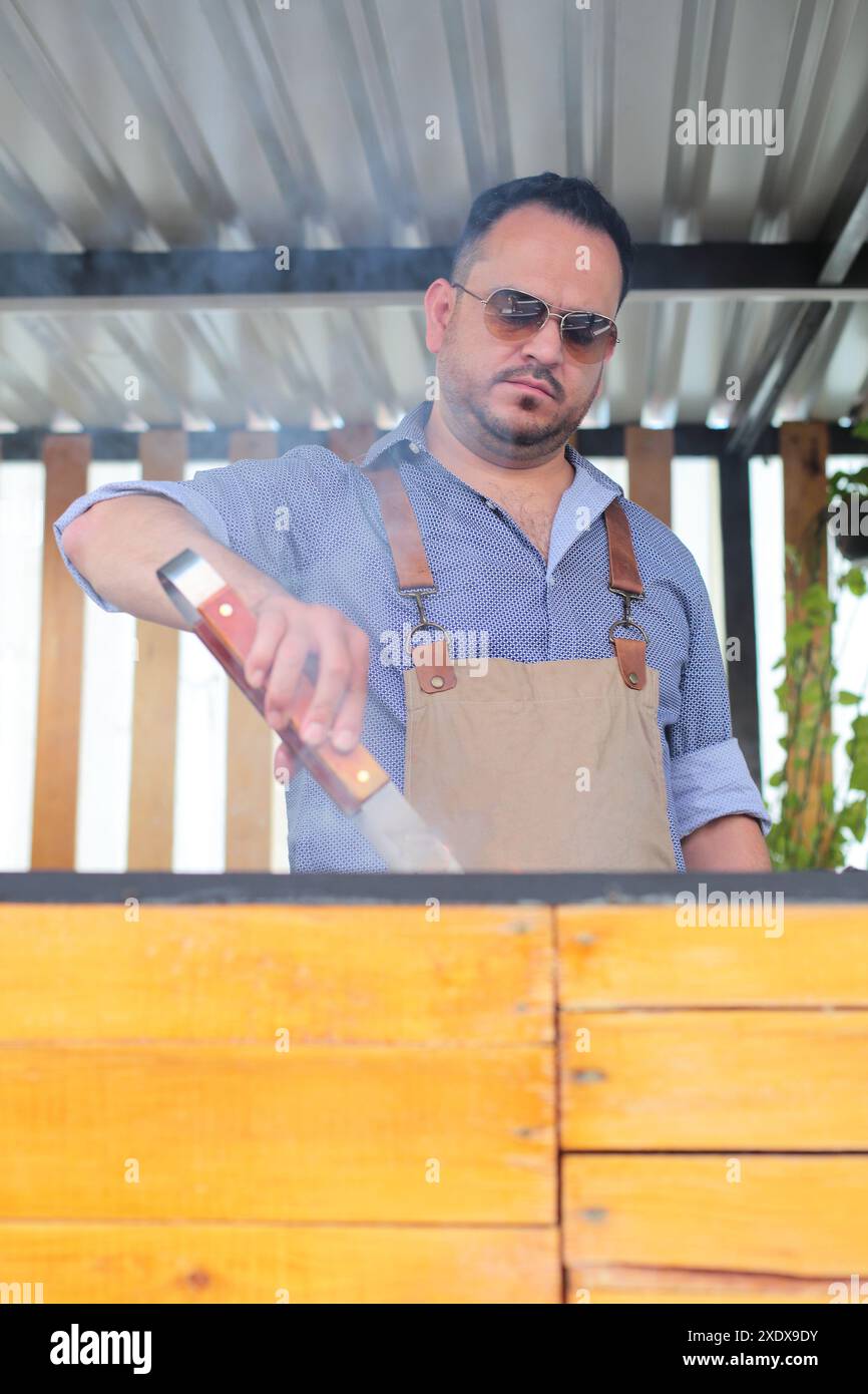 Man kocht Fleisch und andere Zutaten zu Hause auf dem Grill Stockfoto