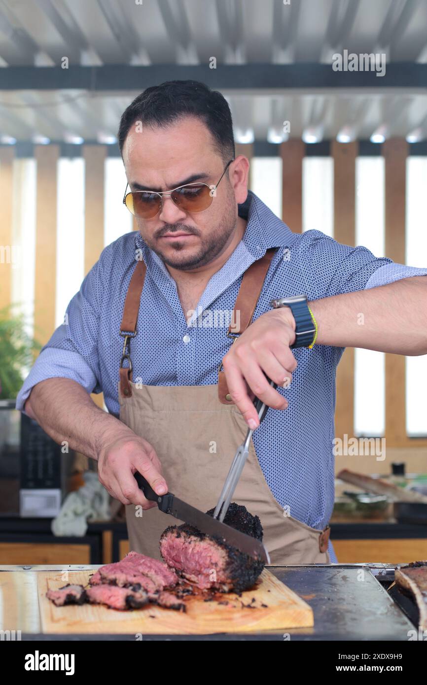 Der Mensch schneidet ein Stück picanha in Streifen Stockfoto