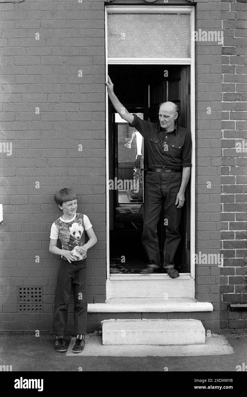 Der pensionierte Kohlebergmann Charlie Hayward und sein Enkel vor der Haustür. Er verbrachte 49 Jahre in der Zeche South Kirkby. Mit 14 Jahren ging er in die Grube und ging 49 Jahre später, als er 63 war, in den Ruhestand. Er hat ein Atemwegsemphysem vor der Haustür seines NUM-Hauses. South Kirkby, Yorkshire England 1979. HOMER SYKES AUS DEN 1970ER JAHREN Stockfoto