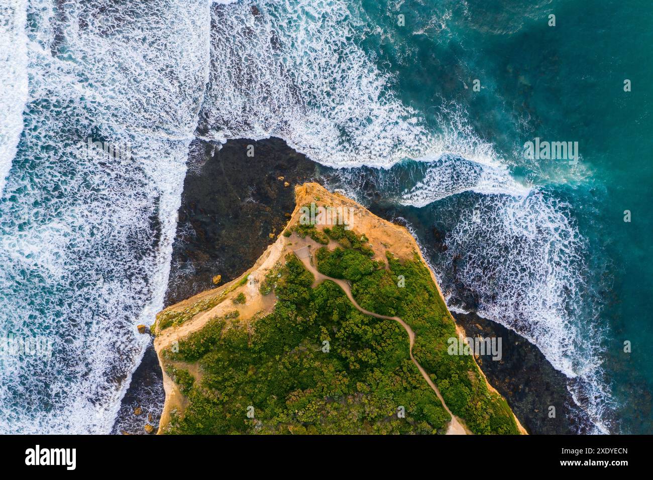 Aus der Vogelperspektive von Wellen, die auf die Basis einer Landzunge in Port Campbel an der Great Ocean Road in Victoria, Australien, aufbrechen Stockfoto