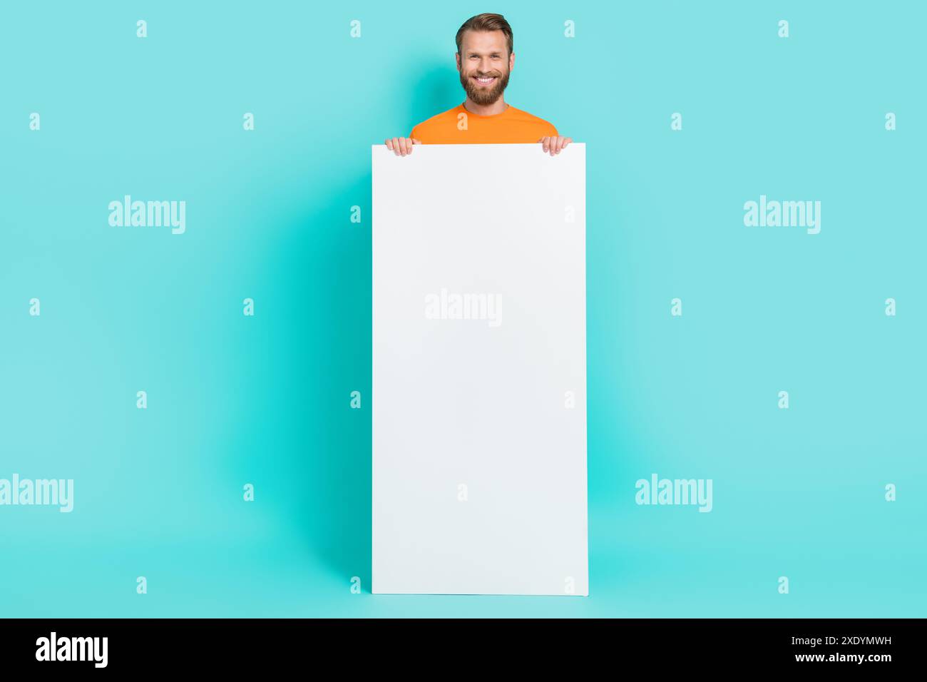 Ganzkörperfoto von lustigem Bartmann mit Telefon tragen T-Shirt isoliert auf blaublauem Hintergrund Stockfoto