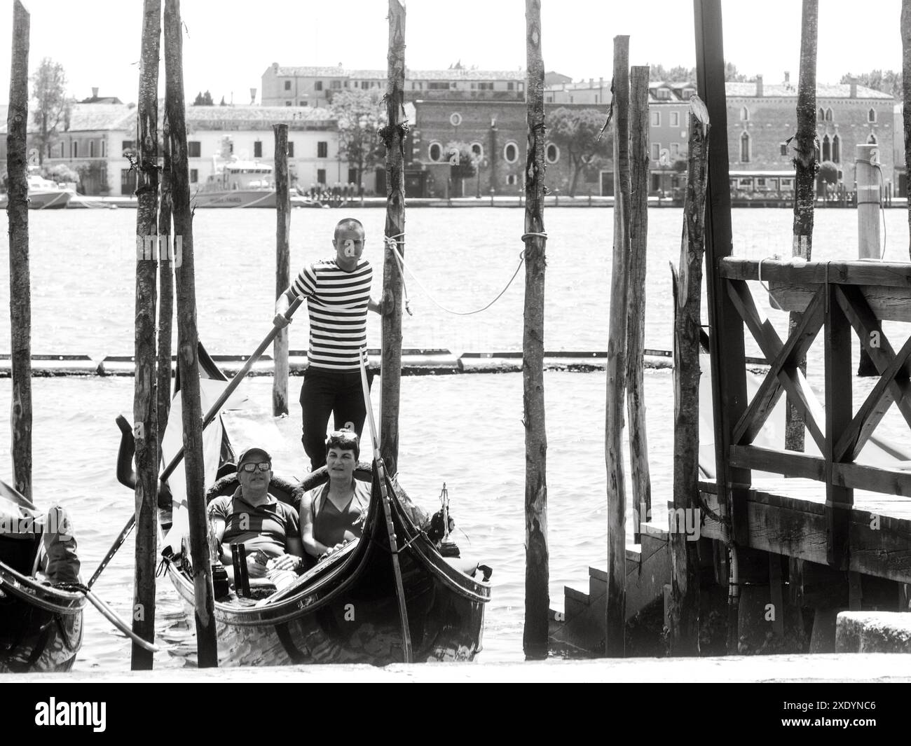 Venedig, Italien - 30. Juni 20220 Schwarzweiß-Bild eines Gondoliers, der in venedig auf Touristen wartet, um an Bord seiner Gondel zu gehen Stockfoto