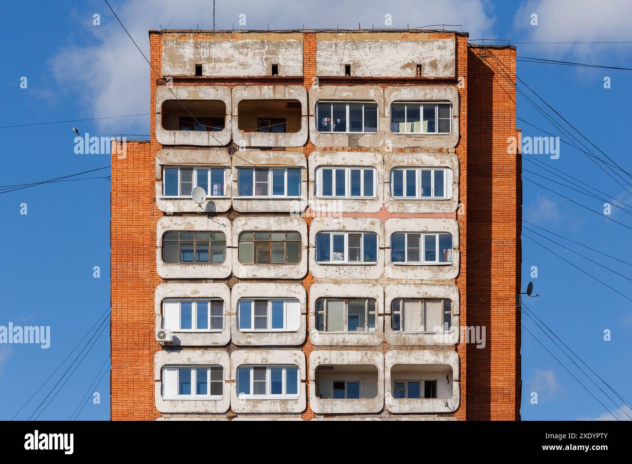 Typisches mittelrussisches Wohnhaus aus Beton und Ziegelsteinhochhaus mit Wohnturm auf blauem Himmel Stockfoto