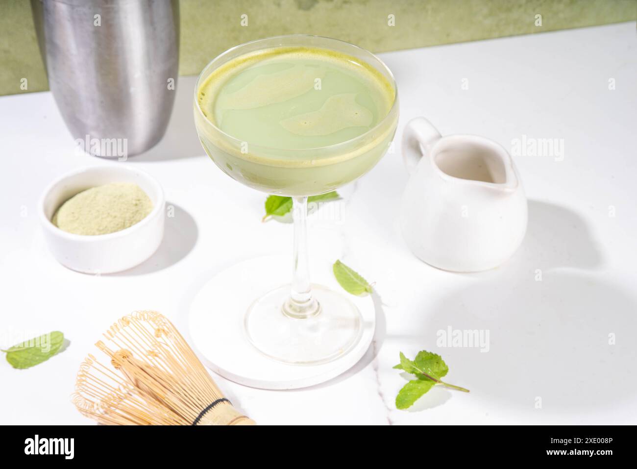 Cremiger Matcha-Martini-Cocktail Matchatini, trendiger kalter Sommercocktail. Matcha alkoholfreier Mocktail oder Alkohol Cocktail, in Martini Gläsern mit GREE Stockfoto