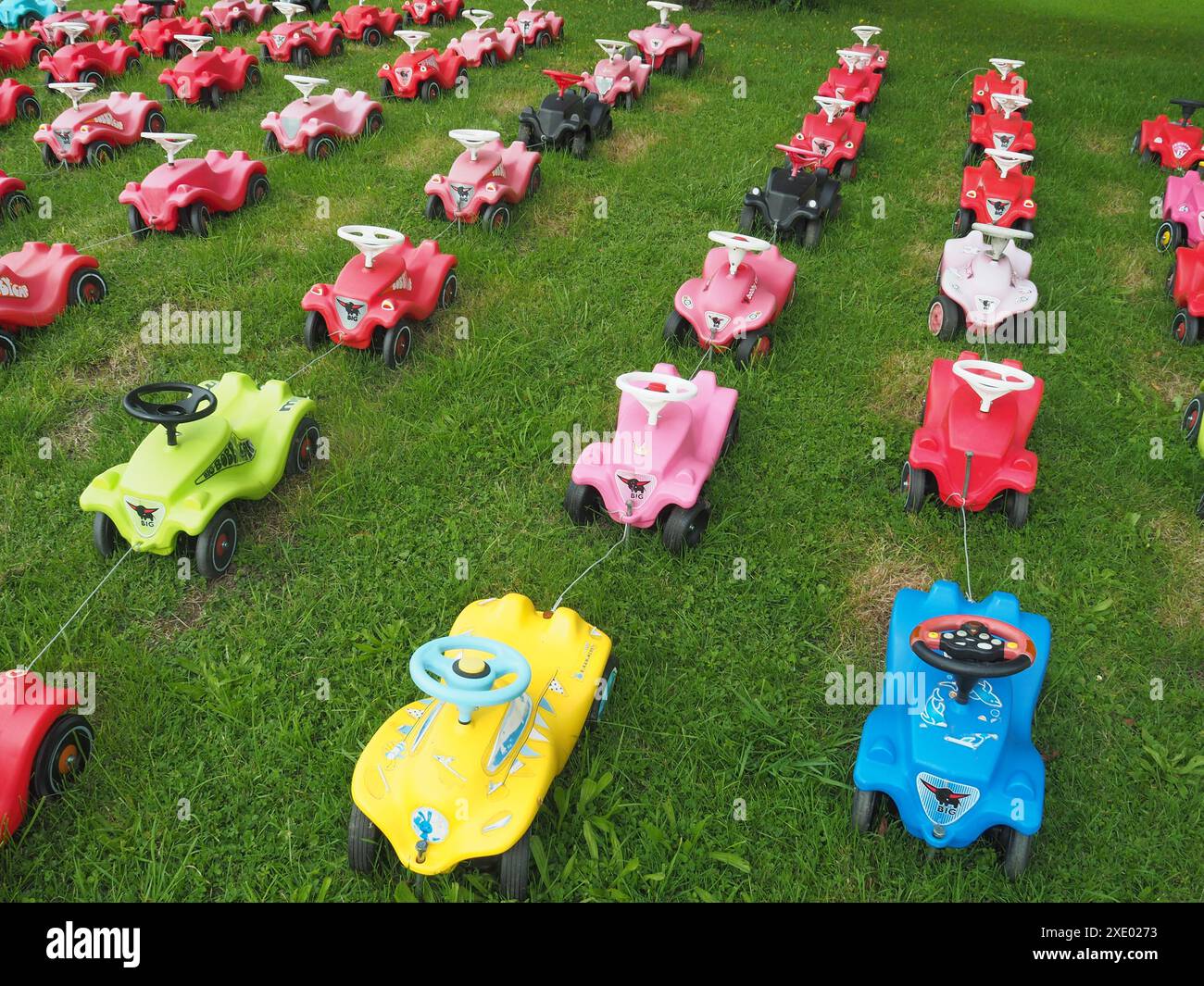 Kinder schieben Autos in Reihen Stockfoto