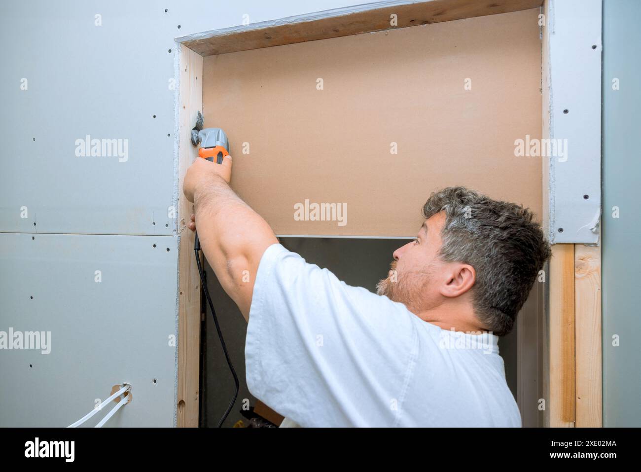 Arbeiter schneidet Trockenbauwände mit Multi-Tool Stockfoto