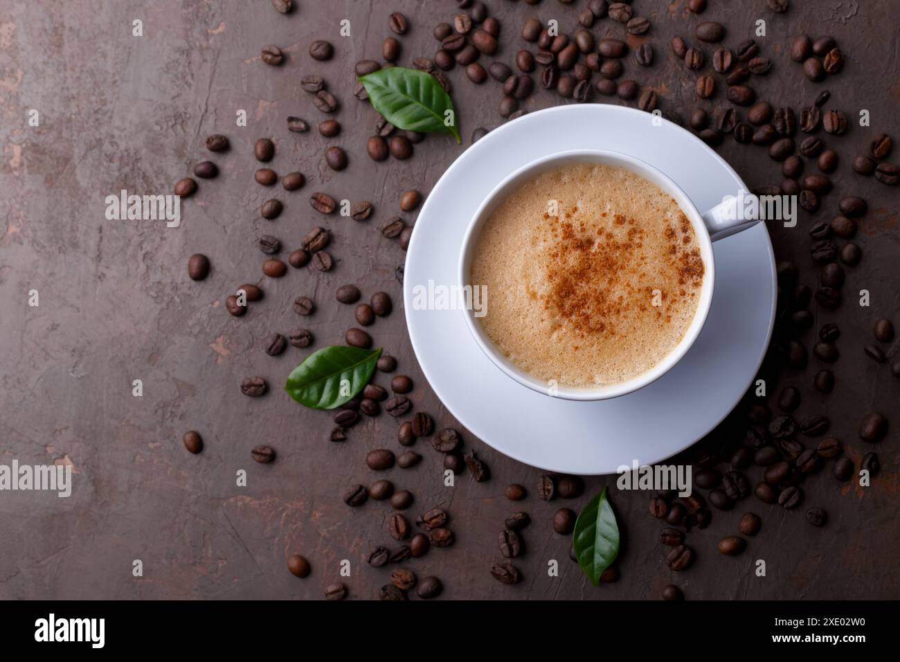 Tasse Kaffee Cappuccino und Kaffeebohnen auf dem braunen Steinhintergrund Stockfoto